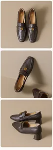 Detail van donkerbruine leren loafers met gouden bloemgesp en stevige blokhakken