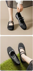 Gros plan de chaussures Mary Jane noires à double bride avec bout en tissu et boucles