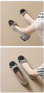 Detailed close-up of grey suede ballet flats with black square toe and bow detail