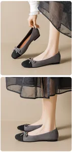 Detail of grey and black ballet flats with elegant bow and premium suede texture