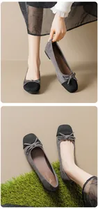 Detail view of ballet flats showing grey suede texture and black bow tie contrast