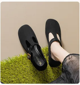 Détail des chaussures Mary Jane en daim noir avec bride en T et boucle dorée élégante