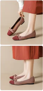 Close-up of suede ballet flats featuring contrast colors and elegant bow detail