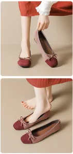 Detailed view of color-block ballet flats featuring a bow accent and suede texture