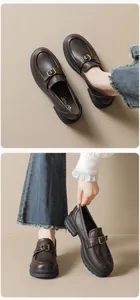 Detail view of brown leather platform loafers with decorative golden buckles