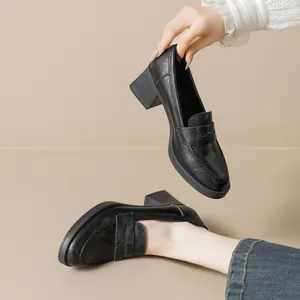 Classic black block heel loafers for women with leather texture and penny strap design