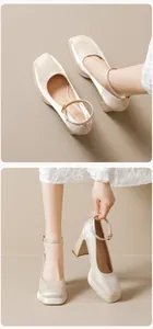 Close-up of champagne satin platform Mary Jane pumps with thick heels and ankle straps