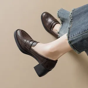 Retro deep brown leather platform loafers with chunky mid-heels on light khaki background