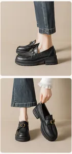 Detail of black platform loafers featuring grain leather and a gold horsebit buckle