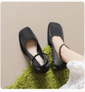 Close-up of black platform Mary Jane shoes with thick heels and gold buckle straps