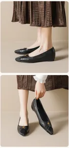 Detail of elegant black pointed-toe flat shoes with vintage gold floral buckle