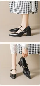 Detail of black Mary Jane heels showing glossy finish and metal stud buckled strap