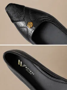 Close-up of black pointed-toe shoe with textured faux fur and golden rose metal buckle