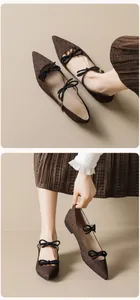 Détail de chaussures Mary Jane pointues marron à pois noirs avec doubles nœuds élégants