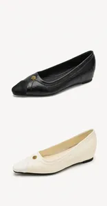 Detail of pointed-toe wedge shoes with elegant golden rose buckle and suede accent