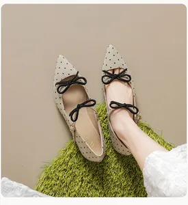 Détail de chaussures Mary Jane à pois noirs avec brides à nœuds et bout pointu