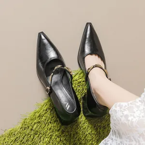 Black patent leather Mary Jane shoes with pointed toe and gold chain strap on low block heels