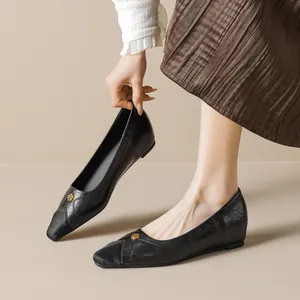 Women's black pointed-toe flat shoe with a golden rose buckle and leather texture