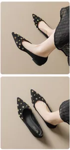 Close-up of black pointed-toe flats featuring decorative gold star and snowflake rivets