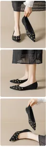 Detail of pointed toe flat shoes in black suede with gold star and stud embellishments