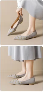 Detail of grey suede pointed toe flat shoes with gold star and round stud decorations