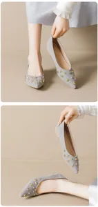 Detail of grey pointed-toe flats with gold star studs and suede-like finish on grey shoes