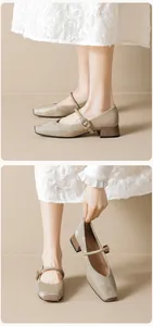 Nahaufnahme beiger Satin-Mary-Janes mit quadratischer Kappe und Metallschnalle