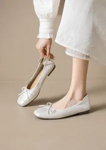 Primer plano de bailarinas tejidas blancas con punta cuadrada y detalle de lazo fino