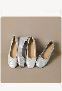 Detalle de bailarinas trenzadas con lazos delicados en acabados blanco y plateado