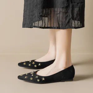 Elegant pointed-toe black suede flats with gold star rivets and snowflake studs