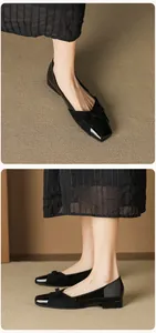 Detail of square toe flat shoes featuring patent leather finish and delicate bow decoration