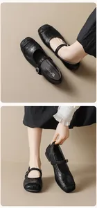 Dettaglio di ballerine Mary Jane in pelle nera opaca con punta dal design traforato