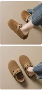 Close-up of brown suede mules with adjustable leather strap and cork footbed detail