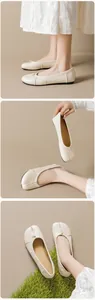 Primer plano de bailarinas Tabi beige con detalle plisado y lazo sobre césped verde
