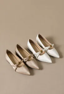 Detailansicht der champagner- und weißen Satin-Mary-Janes mit goldenen Rosenschnallen