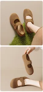 Gros plan de ballerines Mary Jane en daim marron avec bride velcro sur l'herbe verte