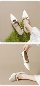 Details von Satin Mary Janes mit spitzer Zehenpartie und eleganten goldenen Blumenschnallen