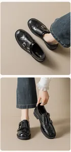 Detailed view of black patent leather brogue loafers with dual monk straps and thick sole