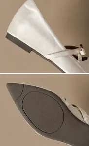 Nahaufnahme von flachem Absatz und rutschfester Sohle an Satin-Spitzschuhen im Mary-Jane-Stil