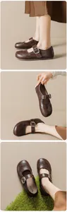 Detail of brown leather Mary Jane shoes with brogue wingtip carvings and metal buckle
