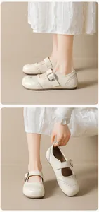 Detailed view of beige Brogue Mary Janes with decorative perforations and buckle strap