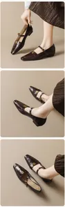 Detalle de los zapatos Mary Jane de cuero marrón oscuro con hebilla floral dorada