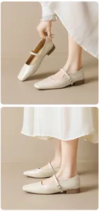 Detailed close-up of cream square-toe Mary Jane shoes with slim strap and metal buckle