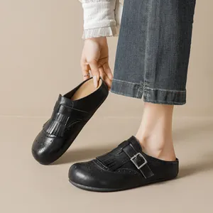 Retro black leather tassel mule with brogue detailing and buckle on a thick sole