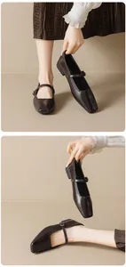 Detail of dark brown square-toe Mary Jane shoes with buckle strap on a beige background