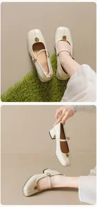 Detail of off-white Mary Jane shoes featuring a square toe and gold rose metal buckle