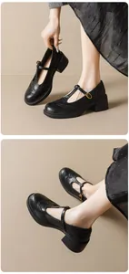 Detail of black T-strap Mary Jane shoes featuring Brogue patterns and chunky mid heels