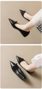 Detailed macro view of black patent leather pointed-toe flats with a bow decoration