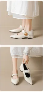 Close-up of cream pointed-toe Mary Jane shoes with heart buckle and stable block heels
