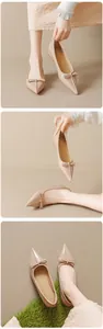 Detailed close-up of nude pointed-toe Mary Jane flats with delicate bow and glossy finish